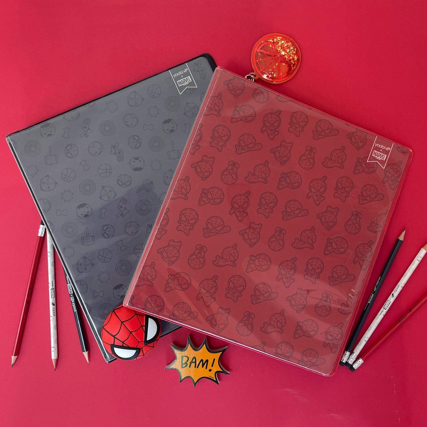 lifestyle image of black icon Avengers binder and red Spider-Man print binder