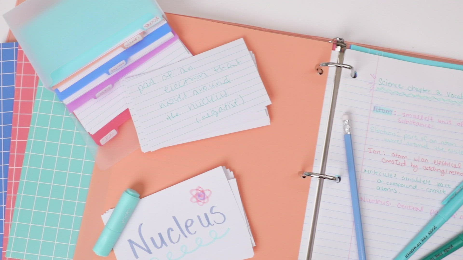 video of binder shown with spiral notebooks set, journal set, dividers, index card set, highlighters, pencils in coordinating colors