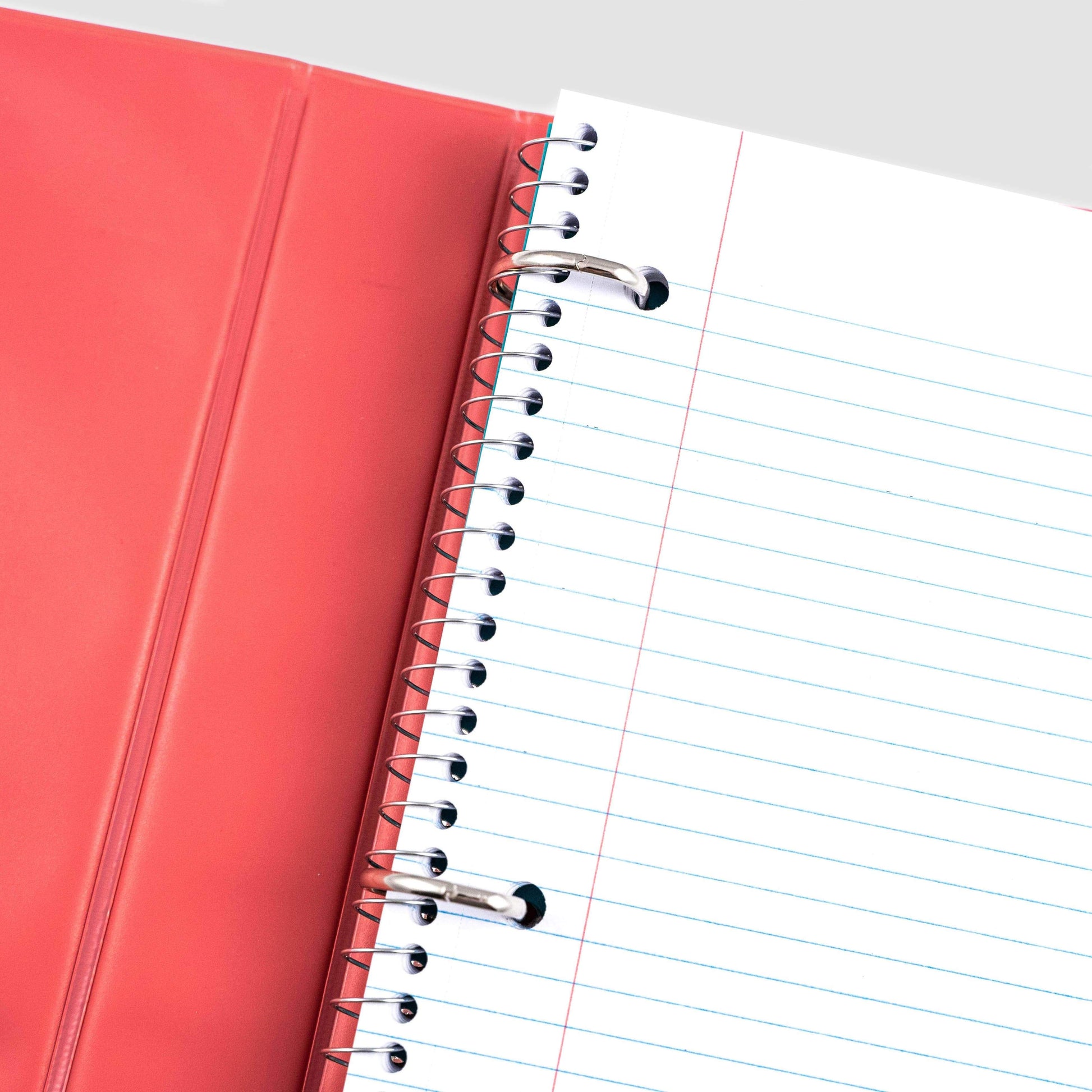 close up of the inside of coral ombre 3-ring 1" binder showing D-ring detail and spiral notebook inside of  binder