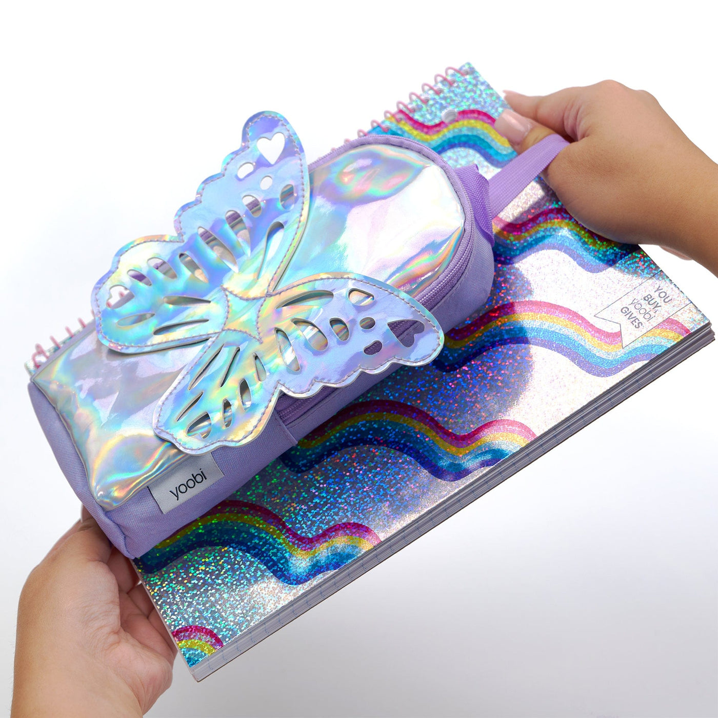 Holographic butterfly backpack pencil case showing case strapped to front of spiral one subject notebook using  its adjustable straps